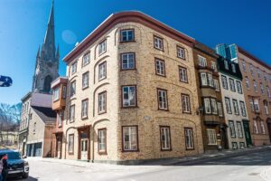 Vue panoramique dun quartier sous-évalué de Québec, mettant en avant des maisons historiques et des rues animées.